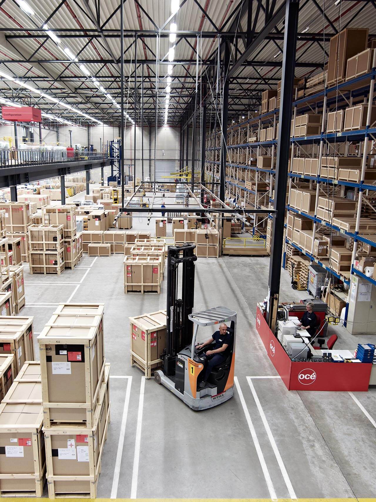 宽敞的仓库里有一排排高大的货架,货架上整齐地堆满了板条箱和盒子